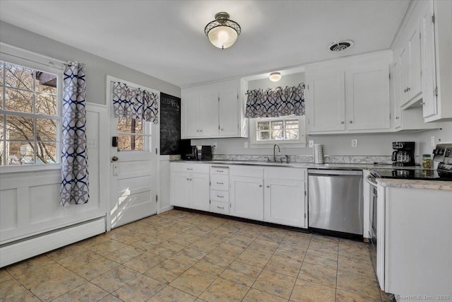 kitchen with a sink, visible vents, white cabinetry, light countertops, and appliances with stainless steel finishes