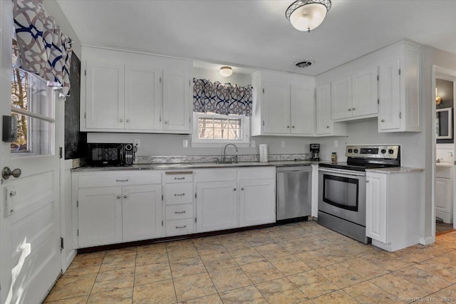 kitchen with visible vents, appliances with stainless steel finishes, a sink, and white cabinetry