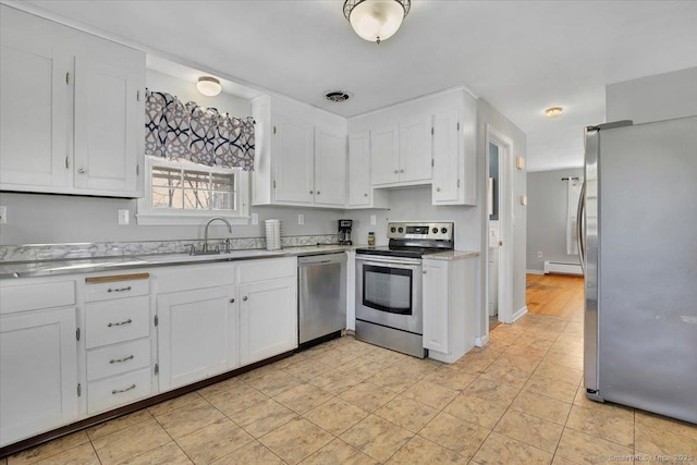 kitchen featuring light countertops, appliances with stainless steel finishes, baseboard heating, and white cabinets