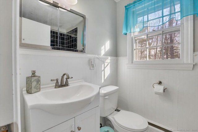 bathroom with toilet, wainscoting, and vanity