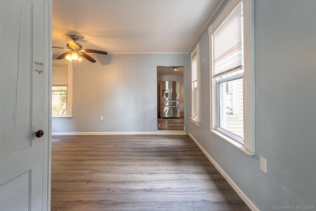 empty room with ceiling fan and dark hardwood / wood-style flooring