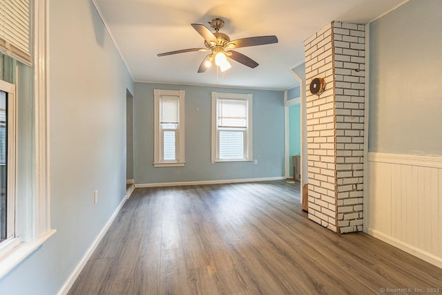 unfurnished living room with dark hardwood / wood-style flooring, crown molding, and ceiling fan