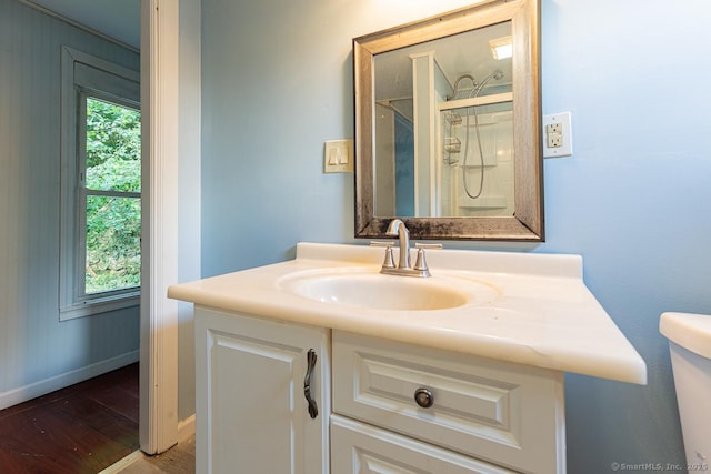 bathroom with hardwood / wood-style flooring, vanity, a healthy amount of sunlight, and toilet