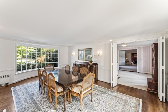 dining area with radiator, baseboards, ornamental molding, and dark wood finished floors