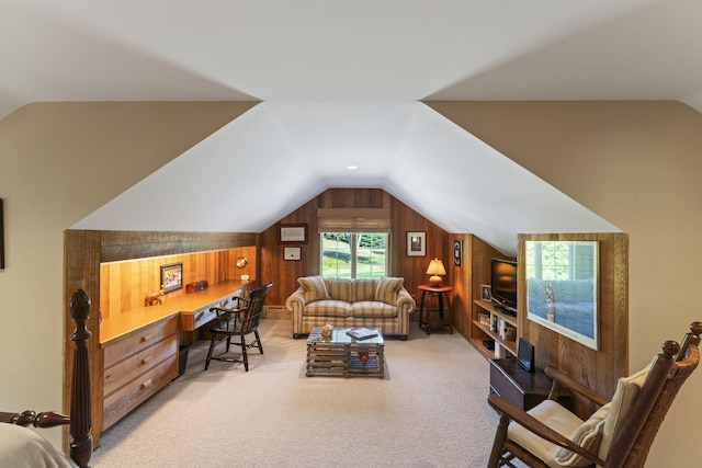 interior space with wood walls, light carpet, vaulted ceiling, and built in desk