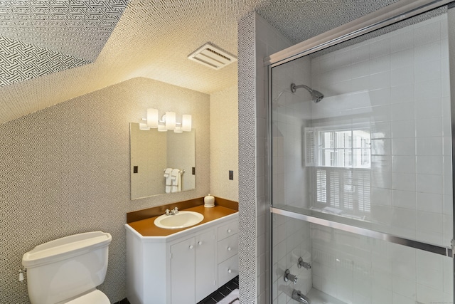 bathroom featuring toilet, visible vents, vanity, a tile shower, and wallpapered walls