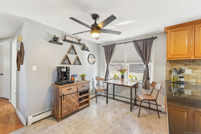 living area featuring a baseboard radiator, a textured ceiling, baseboards, and a ceiling fan