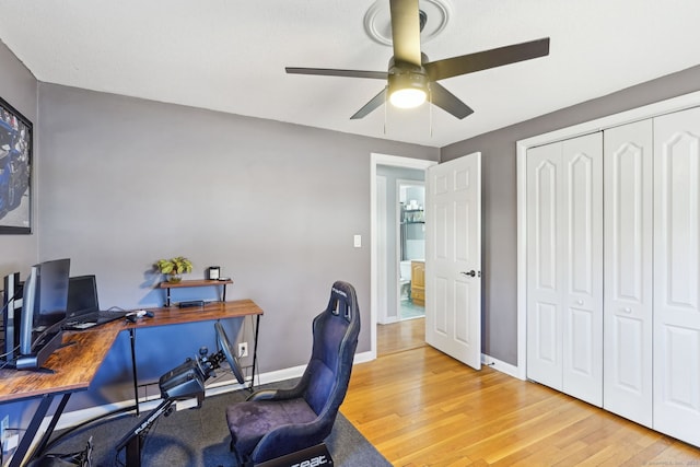 office area featuring ceiling fan, light wood finished floors, and baseboards