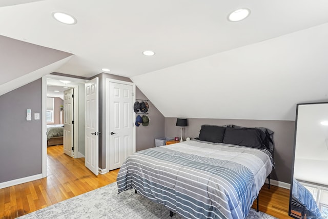 bedroom with baseboards, vaulted ceiling, recessed lighting, and light wood-style floors