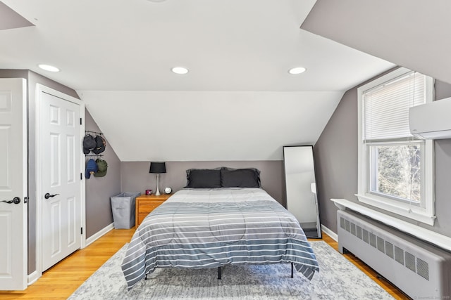 bedroom featuring recessed lighting, baseboards, light wood-style flooring, and radiator heating unit