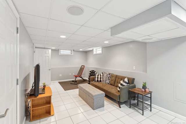 tiled living room featuring baseboards, a drop ceiling, and recessed lighting