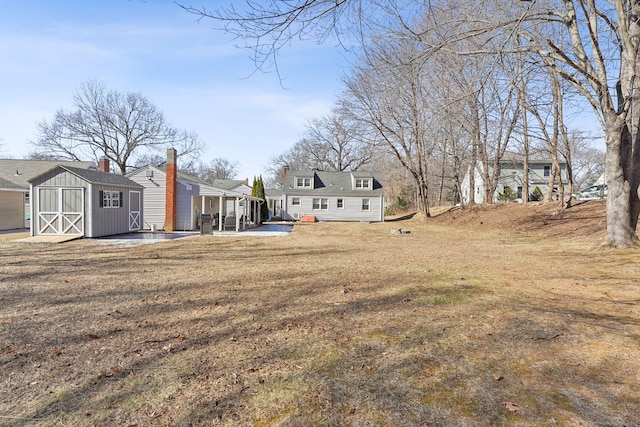 view of yard featuring an outbuilding, a patio, and a storage unit