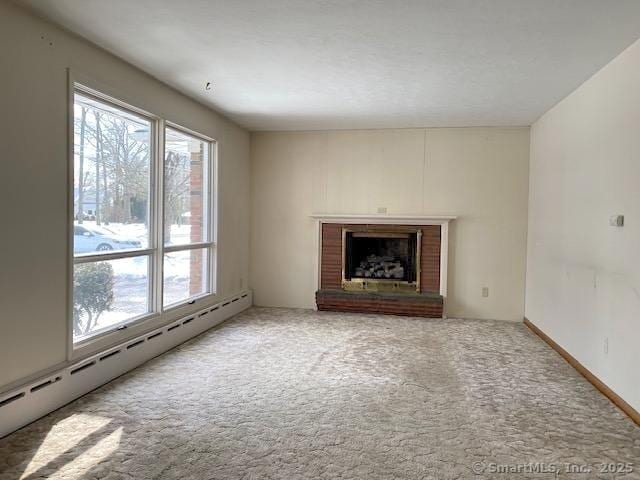 unfurnished living room with carpet, a baseboard heating unit, and a fireplace