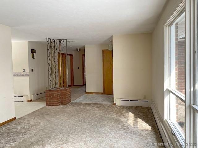 empty room with a baseboard radiator and light carpet