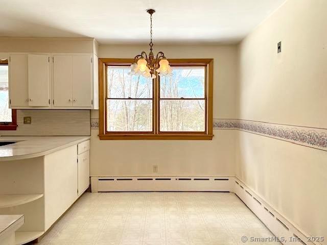 unfurnished dining area with sink and a chandelier