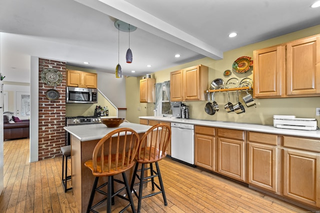 kitchen with a kitchen island, a breakfast bar, pendant lighting, light hardwood / wood-style floors, and stainless steel appliances