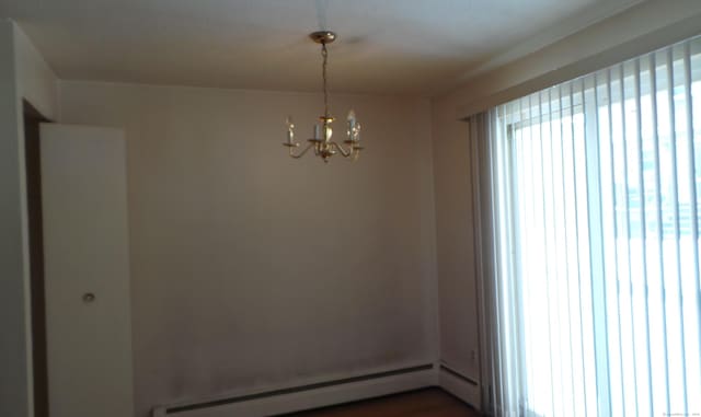 empty room with a chandelier and baseboard heating