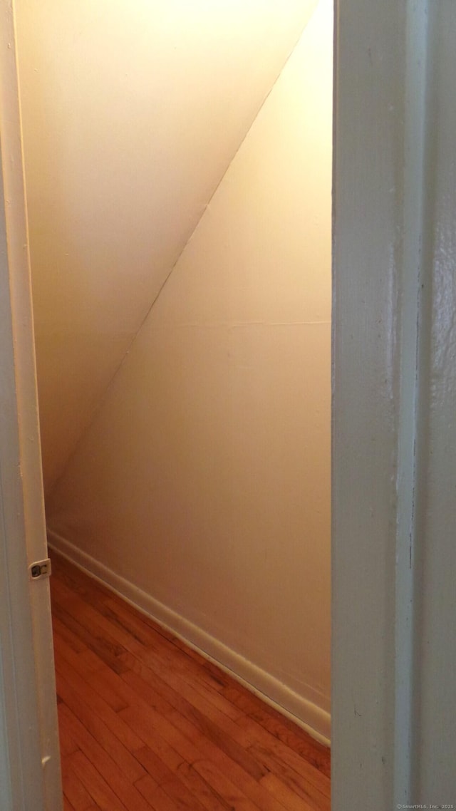 bonus room with vaulted ceiling, wood finished floors, and baseboards