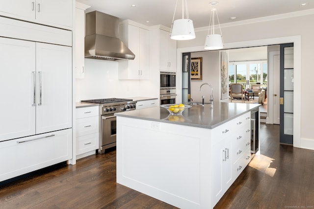 1060 Harbor Rd, Fairfield, CT 06890 - kitchen featuring wall chimney exhaust hood, built in appliances, a sink, dark wood-style floors, and a center island with sink