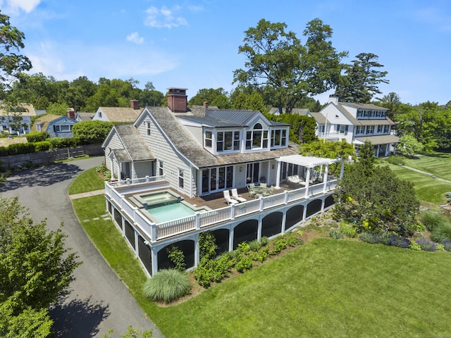 1060 Harbor Rd, Fairfield, CT 06890 - back of house featuring an in-ground hot tub, a chimney, a yard, and asphalt driveway