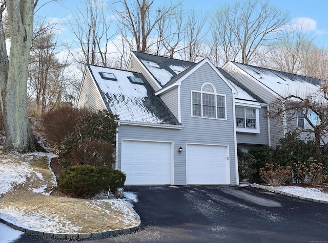 snow covered property with a garage