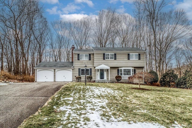 view of front of home featuring a garage and a yard