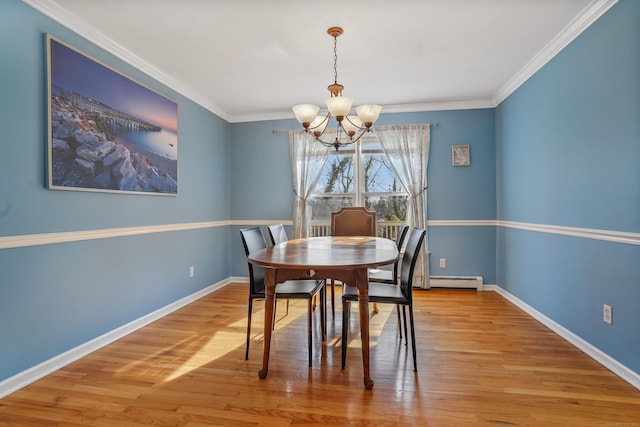 dining area featuring a notable chandelier, crown molding, and light wood-type flooring