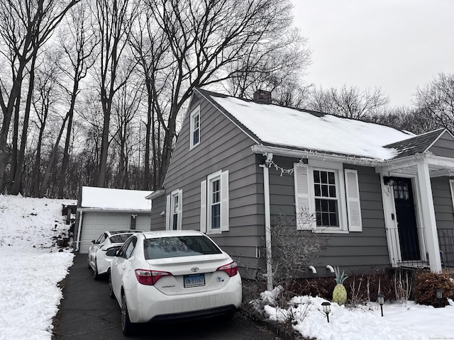 view of snowy exterior featuring a garage