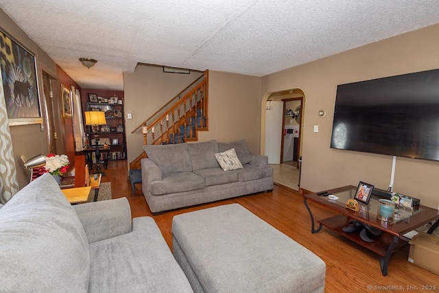 living room with wood-type flooring and a textured ceiling