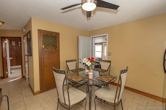 tiled dining space featuring ceiling fan and a textured ceiling