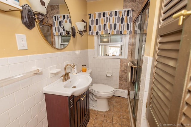 bathroom featuring toilet, an enclosed shower, tile walls, vanity, and tile patterned flooring