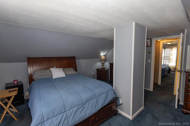 carpeted bedroom with vaulted ceiling and a textured ceiling