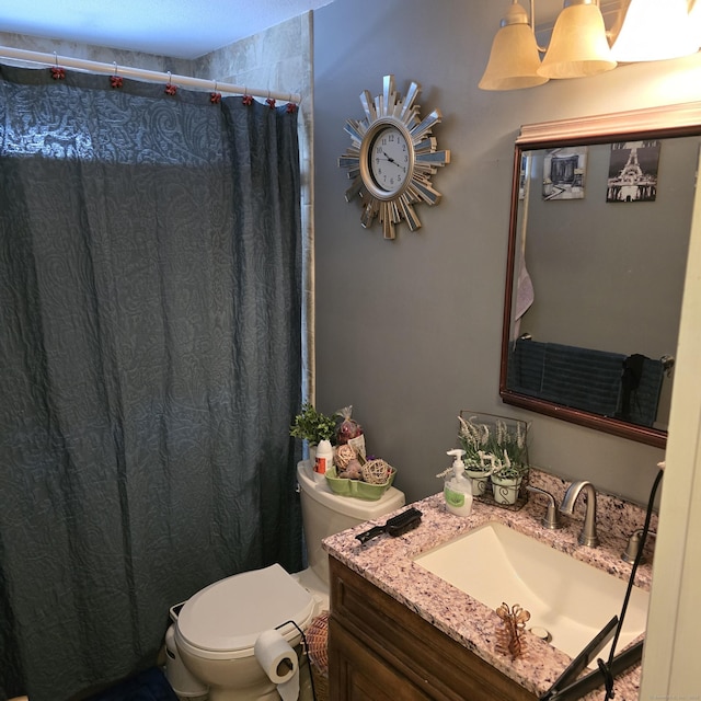 bathroom featuring vanity, walk in shower, and toilet