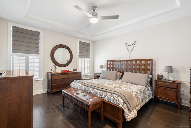 bedroom with ceiling fan, dark hardwood / wood-style flooring, and a raised ceiling