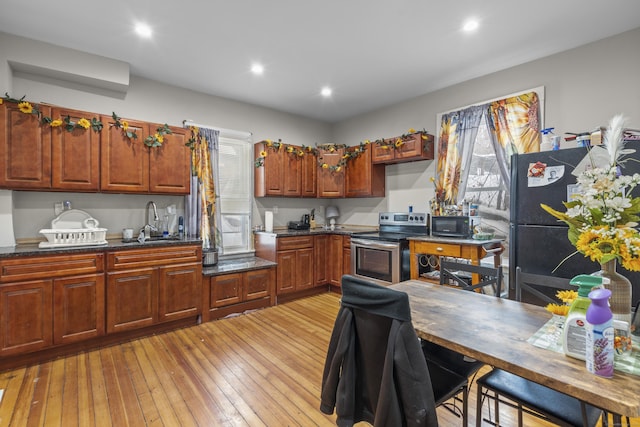 kitchen featuring sink, black appliances, and light hardwood / wood-style floors