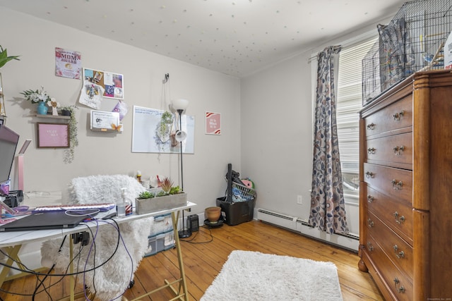 office with a baseboard radiator, a wealth of natural light, and light wood-type flooring