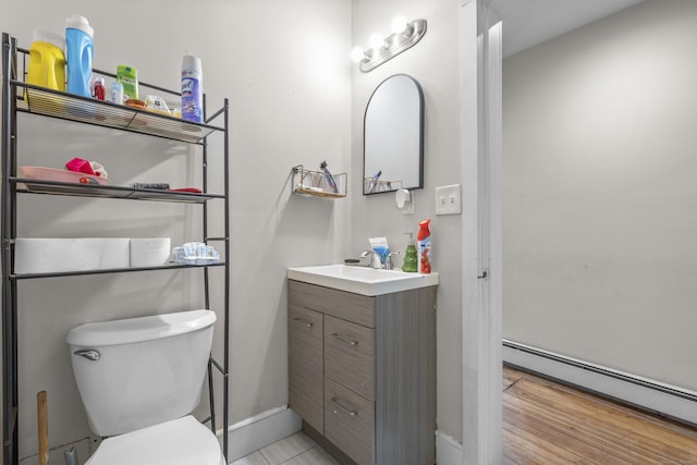 bathroom featuring vanity, toilet, and a baseboard heating unit