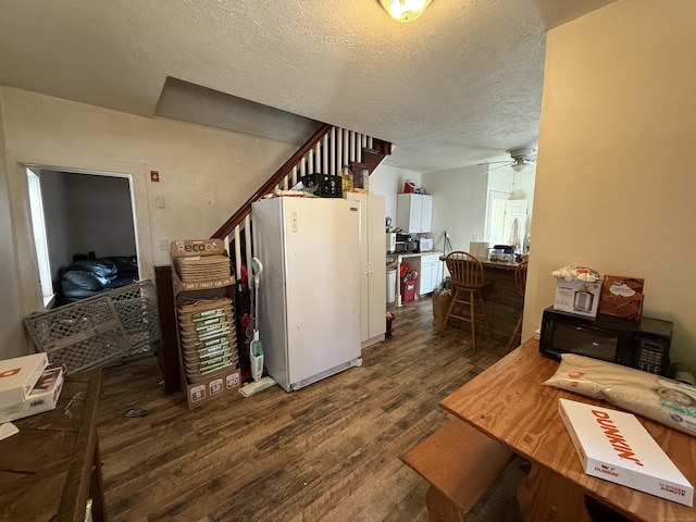 kitchen with dark wood-style floors, ceiling fan, a textured ceiling, and freestanding refrigerator