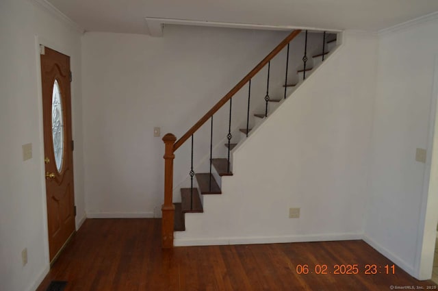 foyer entrance with ornamental molding and dark hardwood / wood-style floors