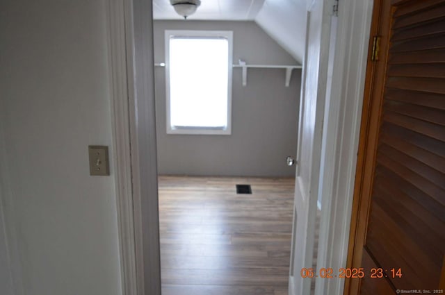 corridor featuring lofted ceiling and hardwood / wood-style floors