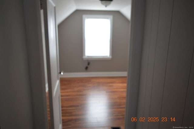 bonus room with lofted ceiling, baseboards, and wood finished floors