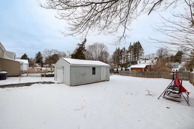 yard covered in snow featuring an outbuilding and a garage