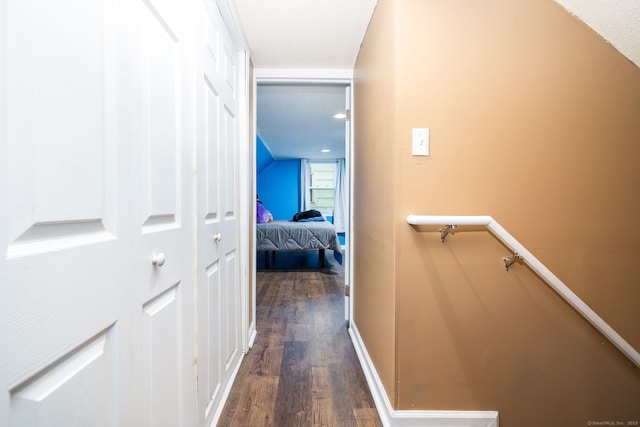 hallway with vaulted ceiling and dark wood-type flooring