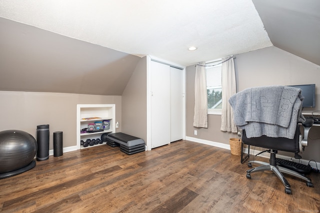 home office with dark hardwood / wood-style flooring, vaulted ceiling, and built in features