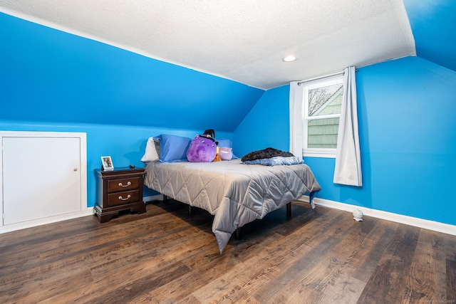 bedroom with hardwood / wood-style flooring, lofted ceiling, and a textured ceiling