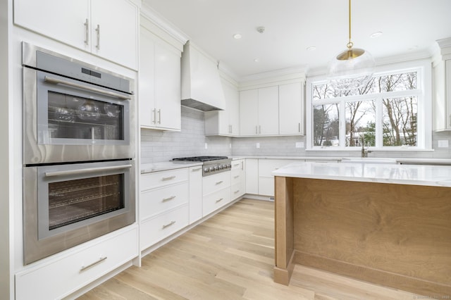 40 Hoyclo Rd, Stamford, CT 06903 - kitchen with white cabinets, stainless steel appliances, a sink, custom exhaust hood, and backsplash