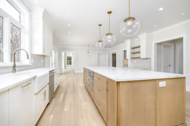 40 Hoyclo Rd, Stamford, CT 06903 - kitchen with a large island, tasteful backsplash, light wood-style floors, open shelves, and appliances with stainless steel finishes
