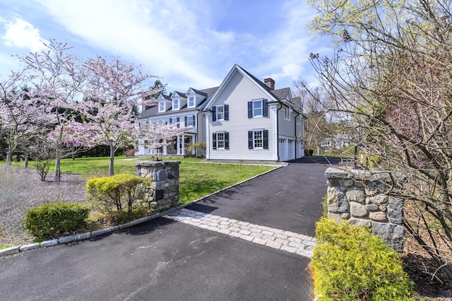 40 Hoyclo Rd, Stamford, CT 06903 - exterior space featuring a garage, a front lawn, a chimney, and aphalt driveway