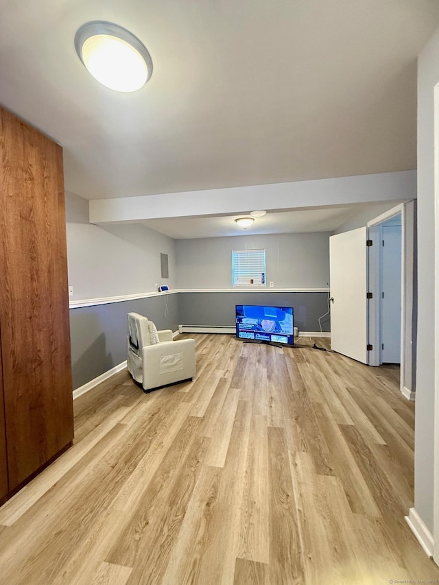 unfurnished room with a baseboard radiator and light hardwood / wood-style flooring