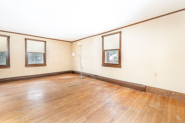 empty room featuring ornamental molding and light hardwood / wood-style floors